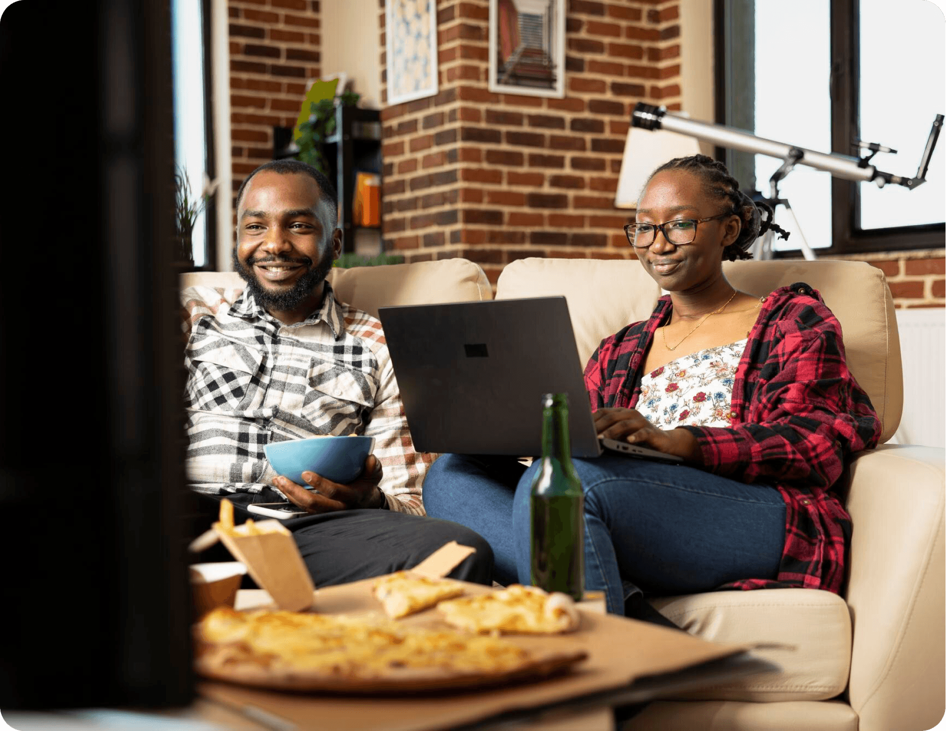 A couple relaxing at home browsing on a laptop