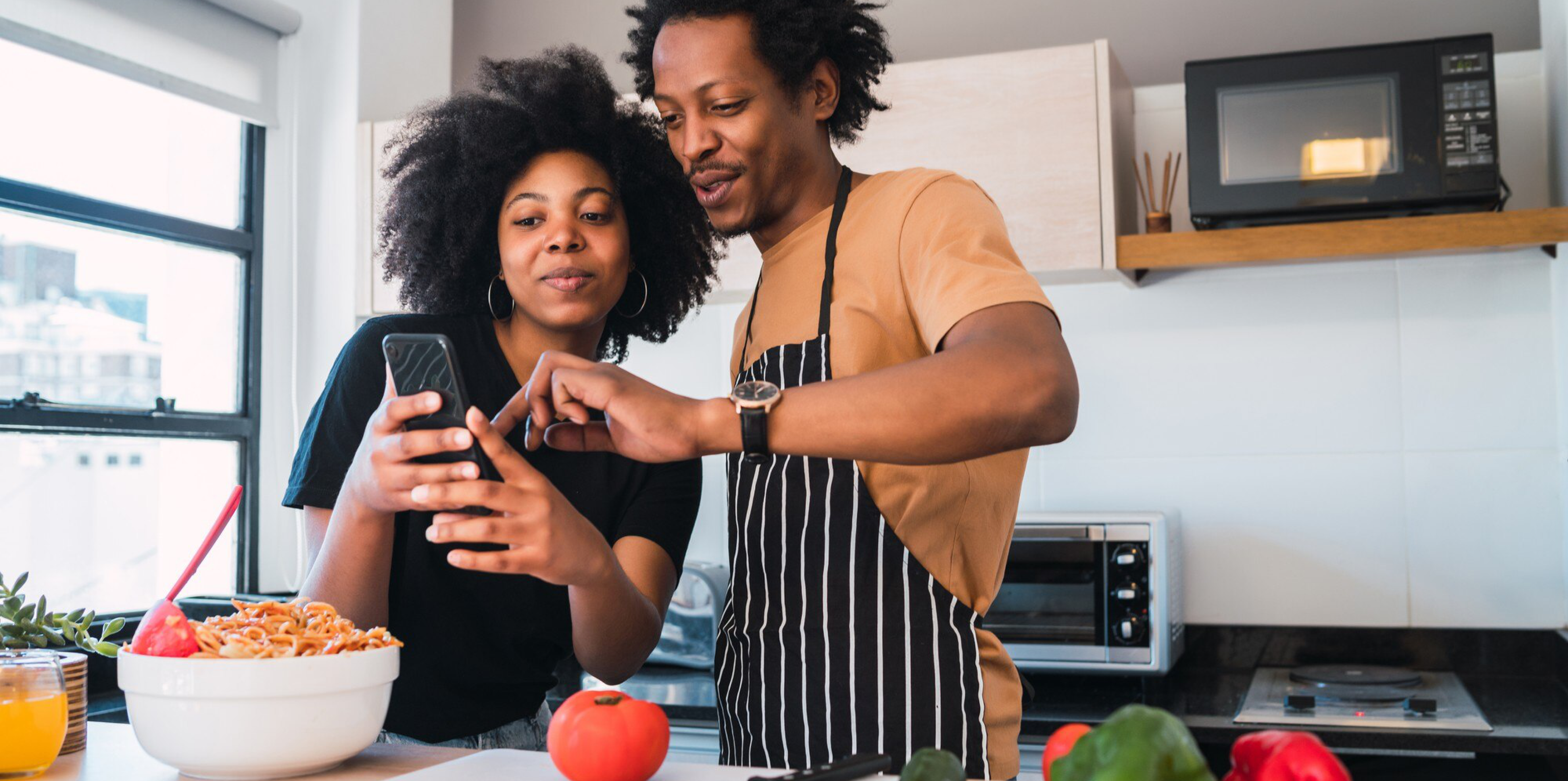 A couple in their kitchen placing a Giddgo order on a phone